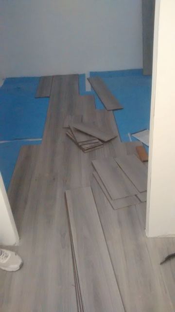 Instalación de suelo laminado gris en curso